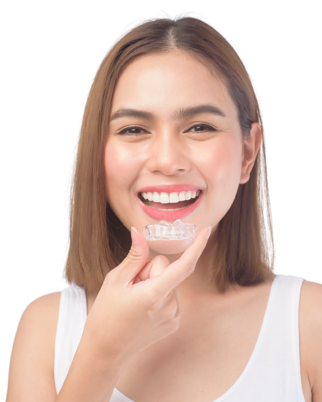 Smiling patient holding an Invisalign clear aligner